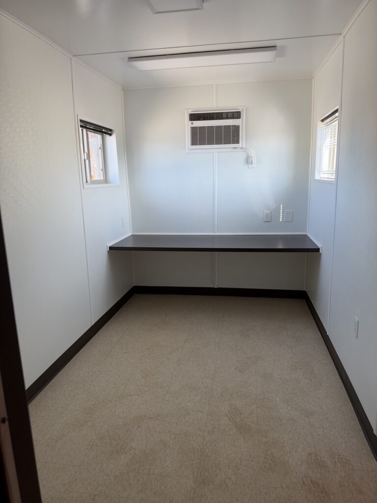 Inside a 40 foot container all office with countertop desk and windows